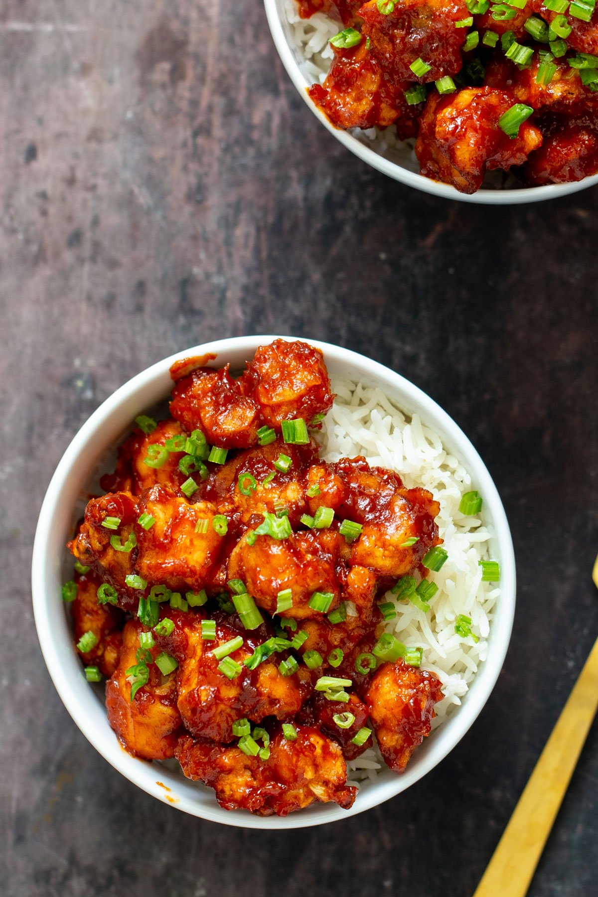 gochujang cauliflower wings in bowls with rice and green onions