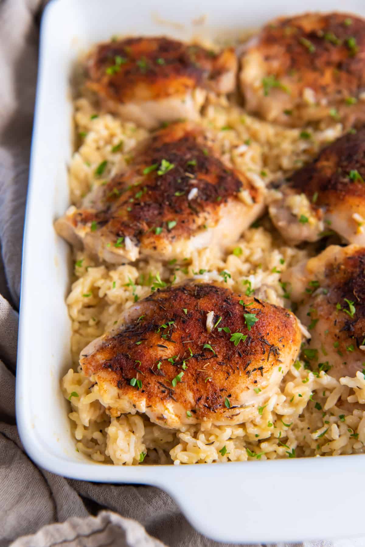 three-quarters view of baked chicken and rice in a casserole dish.