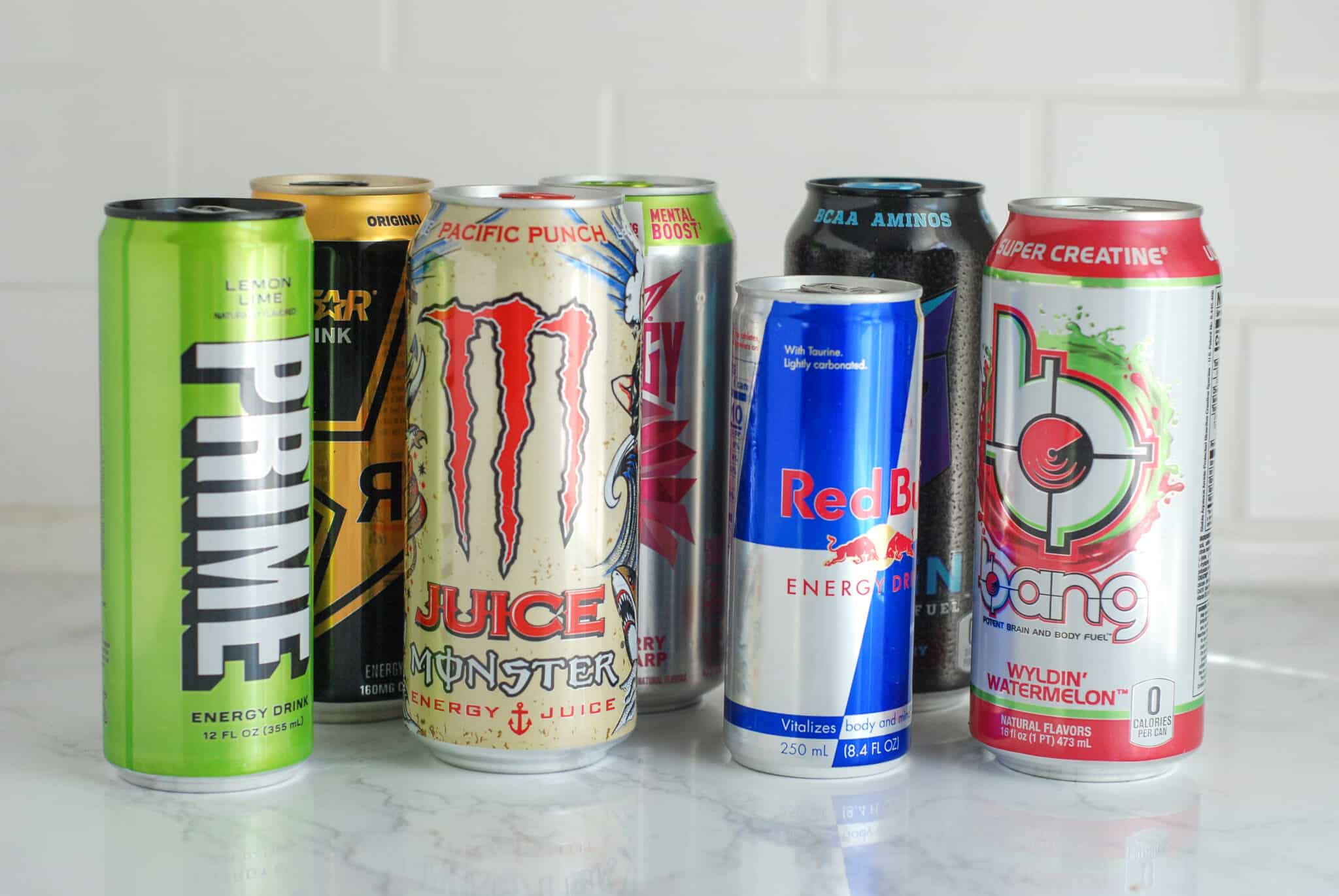 An array of energy drink cans sits on a white counter
